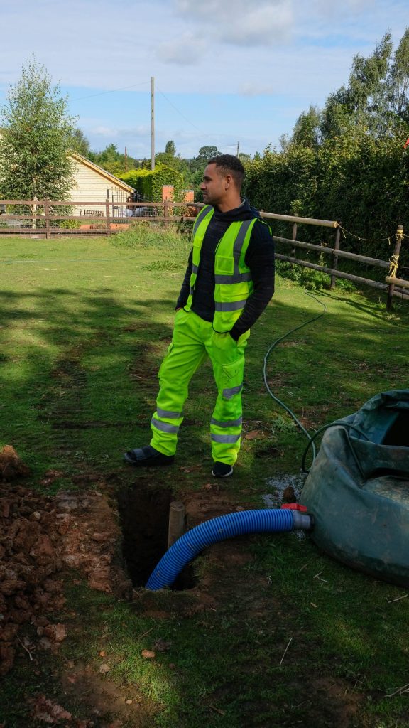 A percolation test pit being filled from the bowser, with the standpipe set in the pit